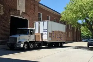 Boxes on flatbed truck parked outside building.